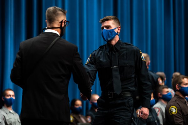 Recruit shakes the hand of Williamson Wallace, director of Criminal Justice Training.