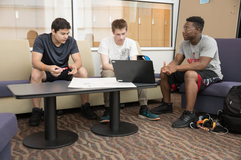 three students in front of a computer