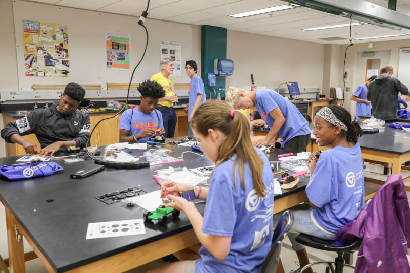 Campers building solar-powered cars during an interactive session.