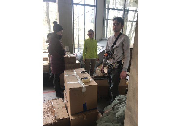 three people standing near boxes