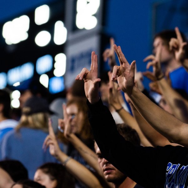 GVSU Students at a football game holding their hands up in the Laker L.