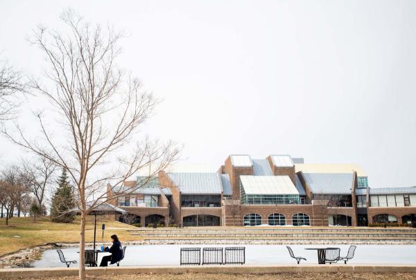 Student sitting outside by the Kirkhof Center.
