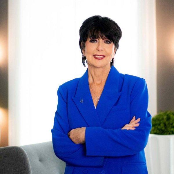 President Philomena V. Mantella stands with her arms crossed in a modern, well-lit interior for a portrait.