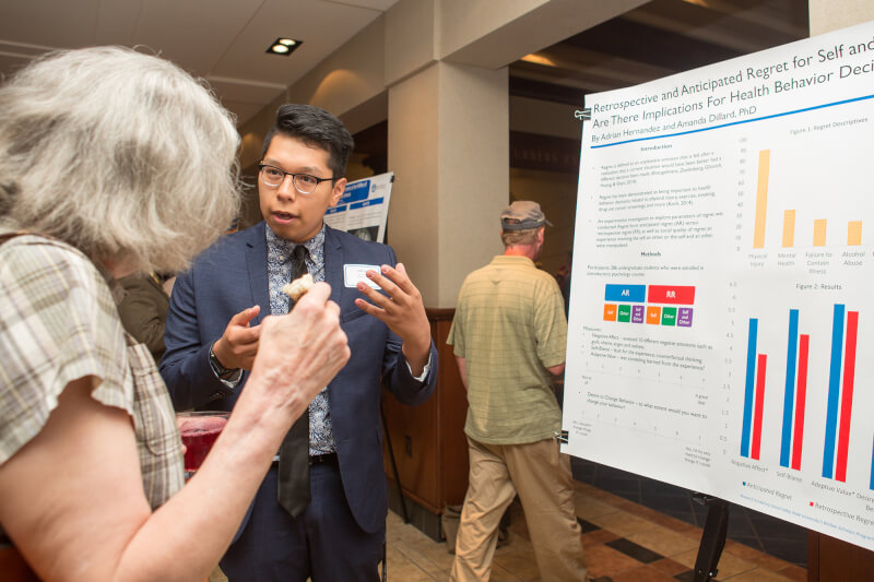 two people standing before a poster 