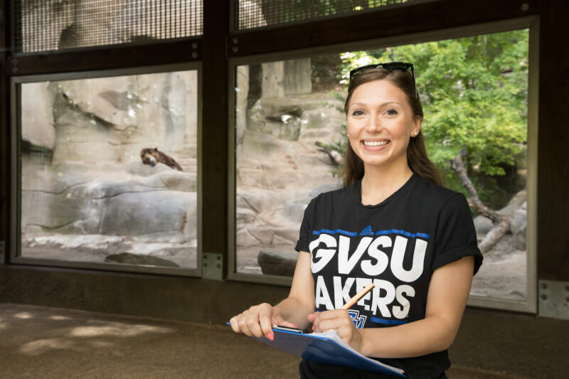 woman at zoo in front of enclosed cage