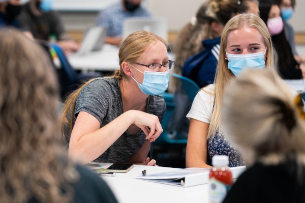 Students socializing at a table in the DeVos Center for Interprofessional Health.