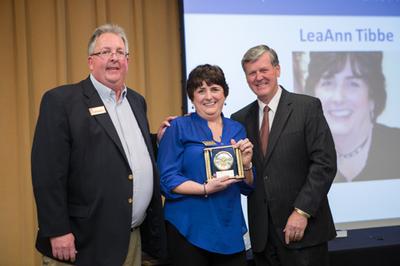 LeaAnn Tibbe stands with Bob Stoll, left, and President Thomas J. Haas. She earned the A/P Achievement Award.