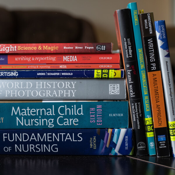 A pile of textbooks on a table, close up.