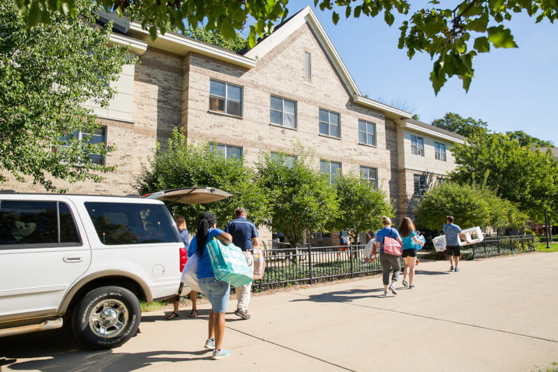 A photo of students and volunteers carrying boxes. 