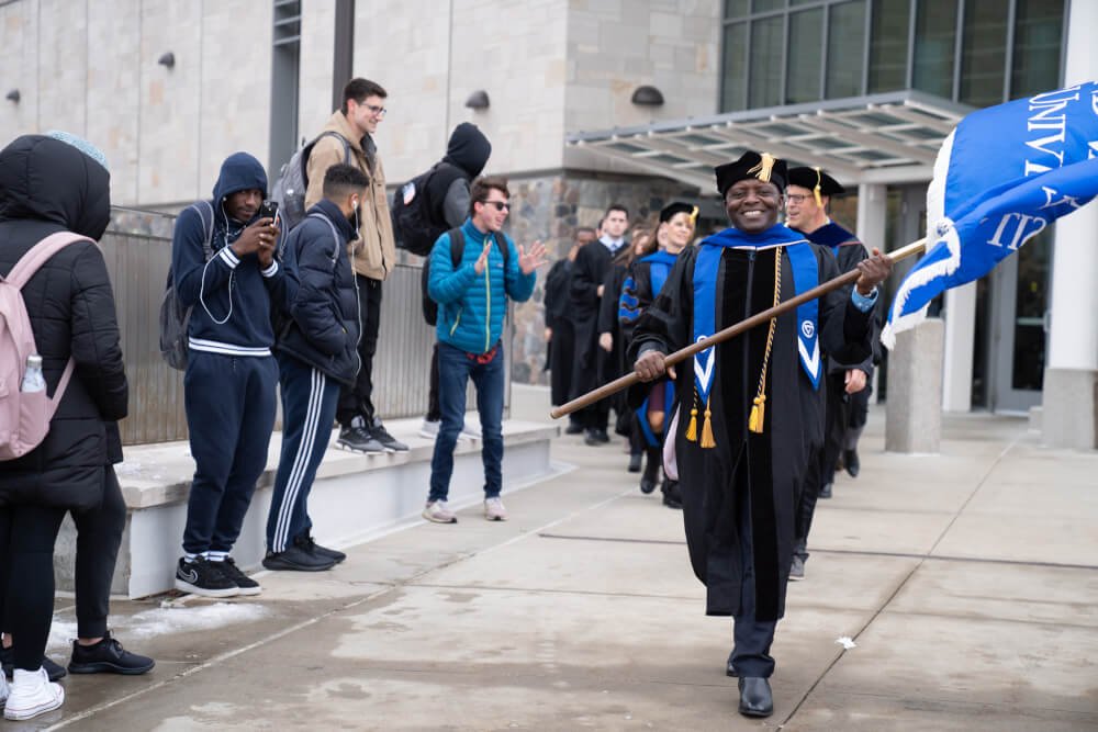 Felix Ngassa, chair of the University Academic Senate, leads the procession from the Mary Idema Pew Library to the Fieldhouse for the investiture ceremony.