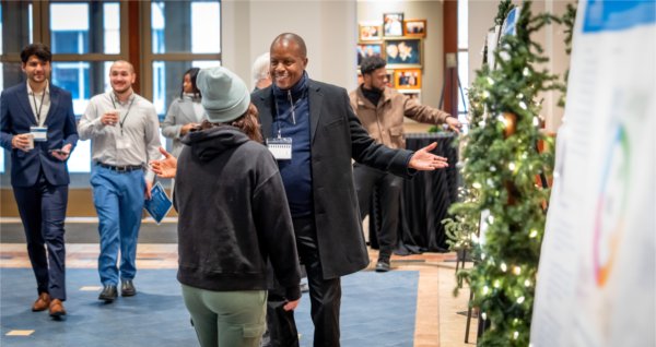 Two students discuss a research project focused on computer science in front of a poster presentation.