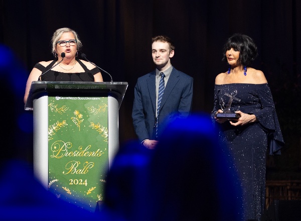 Michelle Rhodes, associate vice president for financial aid, accepts the Presidents' Award on stage at the Presidents' Ball.