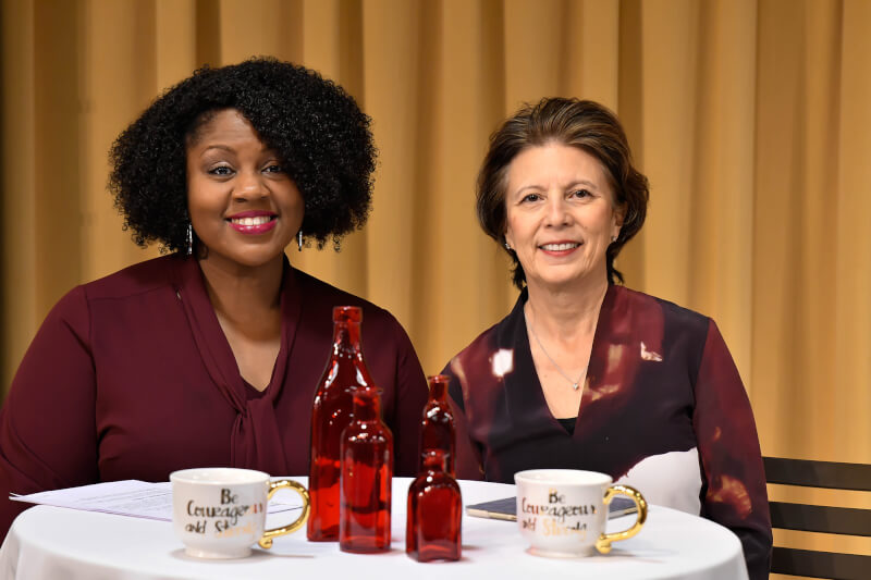 two women, seated at table