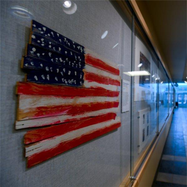 A painted wood art rendering of the American flag by Willian Henry Edgerton hangs in the Lake Ontario Wall Gallery as part of the Becoming America: Our Past, Present, and Future at 250 exhibit.