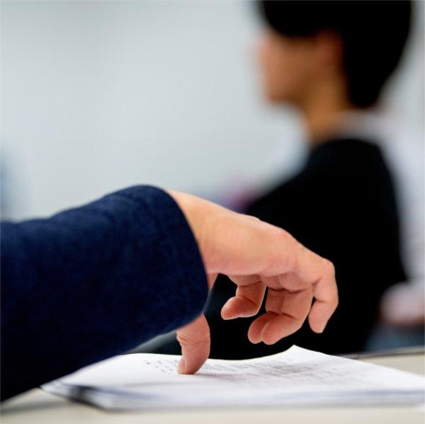 Dr. Besel places his thumb on the meeting notes.