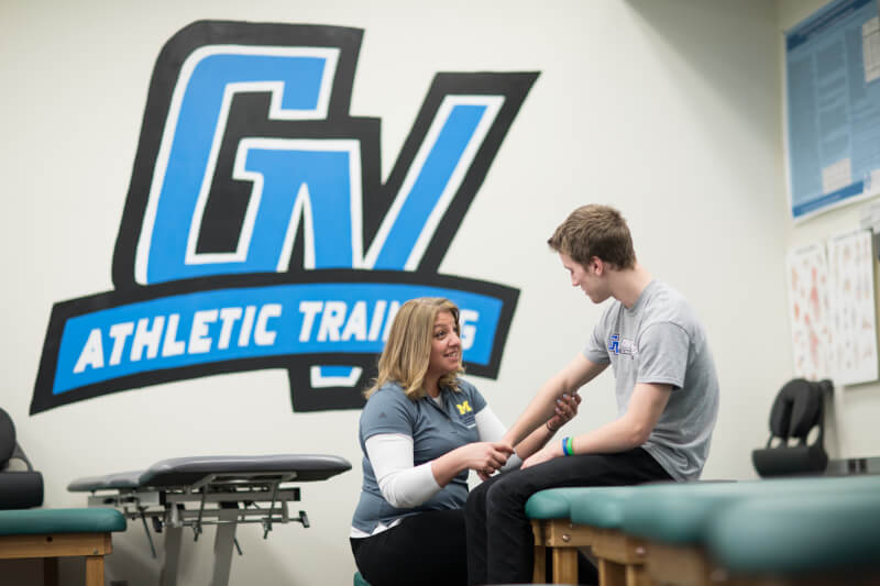 A photo of an athletic trainer working with a student.