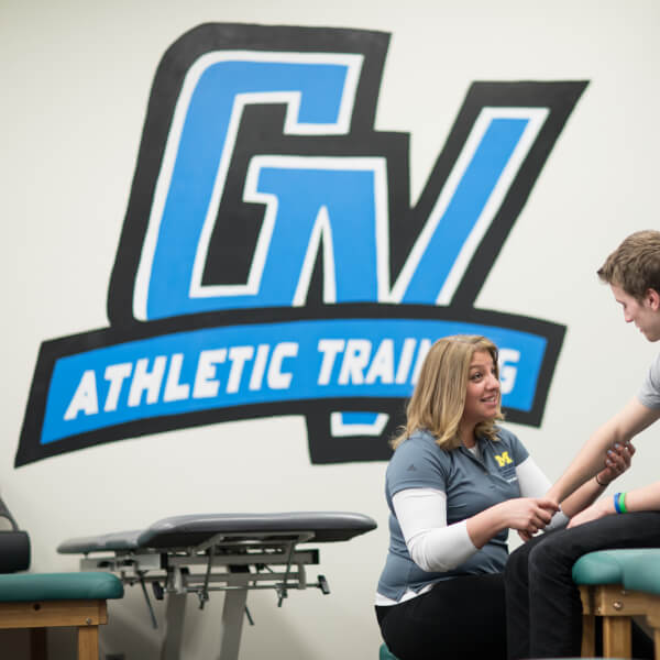 A photo of an athletic trainer working with a student.