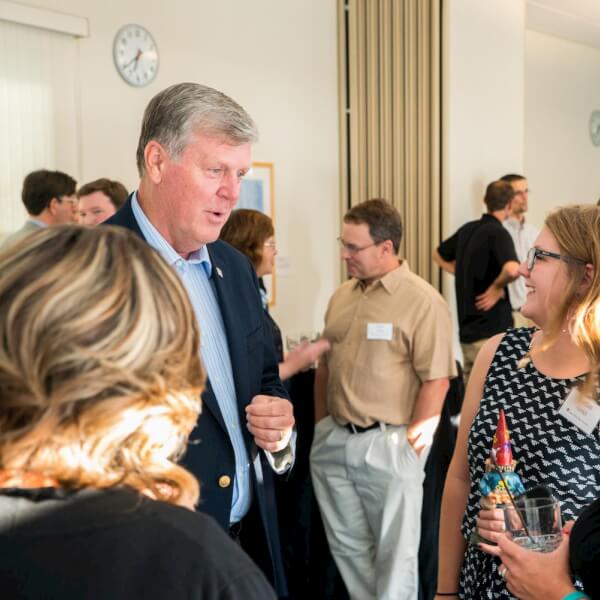 Grand Valley President Thomas J. Haas visits with alumni and students.