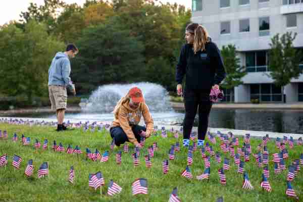 Students place U.S. flags on lawn of Kirkhof Center for anniversary of September 11, 2001.