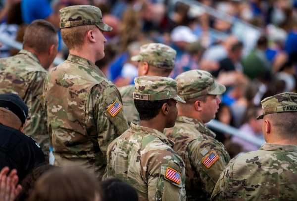 Members of military standing at football game