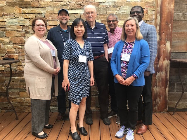 seven people posing for a photo in two rows