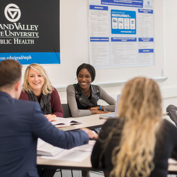 Public health faculty members and students sitting around a table.