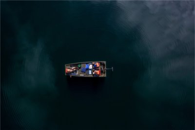 Three staff members from the Annis Water Resources Institute sit a boat on a lake.