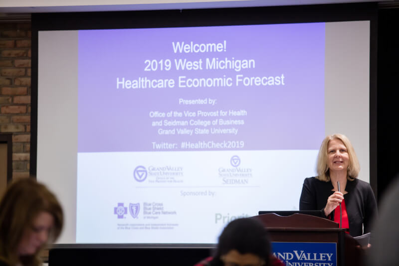 woman speaking into microphone at podium