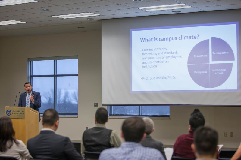 man behind podium in front of audience