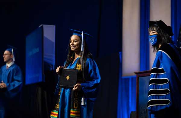 A student crosses the stage at the Winter 2021 graduation celebration