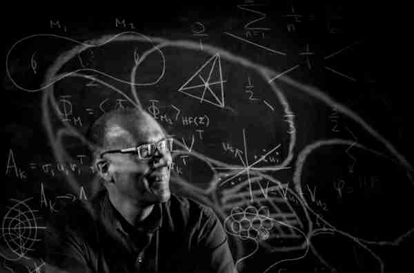 David Austin with several math equations on glass in front of him