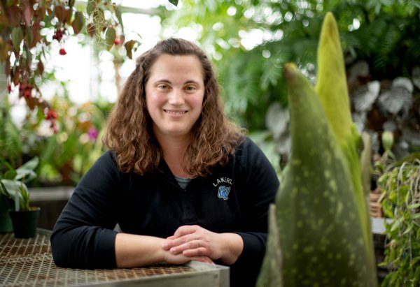 Christina Hipshier smiles while standing with the corpse flower.