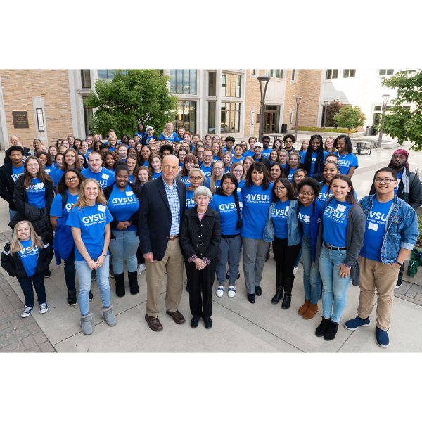 Bob and Ellen Thompson, President Mantella stand with student scholarship recipients. Most wearing blue shirts that read GVSU.