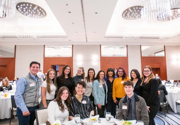President Philomena V. Mantella poses for a photo with GVSU students who attended the panel discussion hosted by the Economic Club of Grand Rapids on March 27.