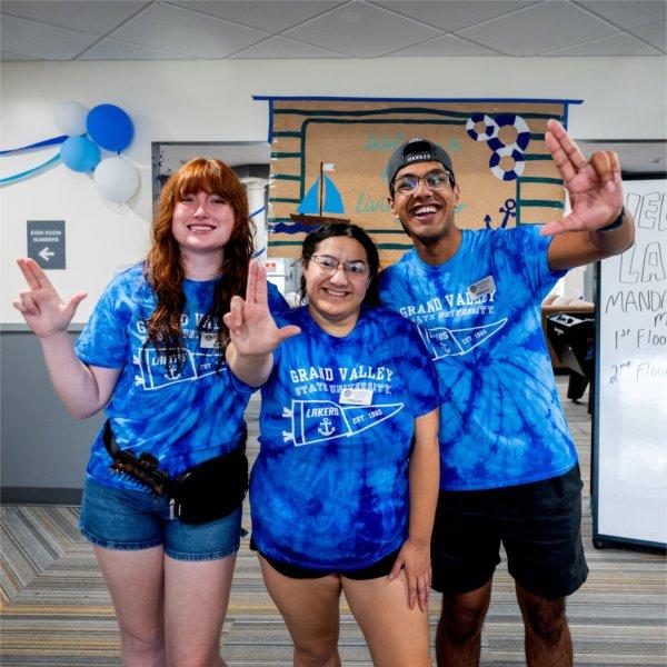 Resident advisors flash the "Anchor Up" hand sign to welcome new students to campus
