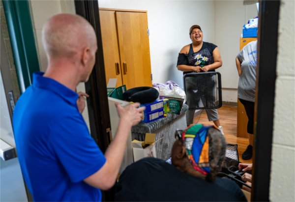 Kevin Conn, assistant vice president for Student Affairs, Housing and Residence Life, gestures while talking with a student from a doorway in a GVSU living center.