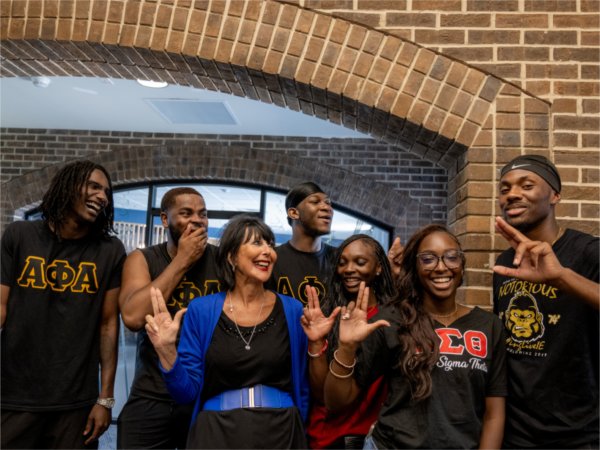 President Philomena V. Mantella anchors up with members of the Alpha Phi Alpha Fraternity and Delta Sigma Theta Sorority