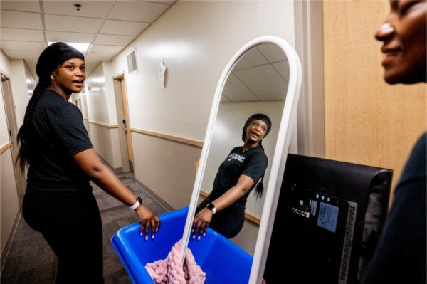Junior allied health sciences student Tia Norman, left, looks back to her mother Tanisha Norman as they push a cart of belongings to her room in Winter Hall. 