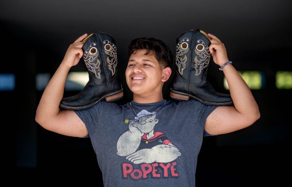Student David Arellano poses with a pair of boots that remind him of dancing and celebrating with his family. 