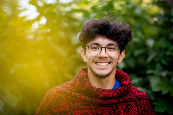 Student Sebastian Lerma poses for a picture in a hand-woven poncho.