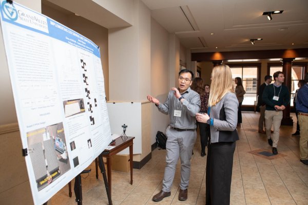 A graduate student presents their poster at the Graduate Showcase. 