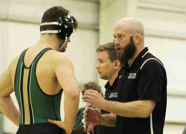 Grand Valley's new men's wrestling coach speaks with a wrestler during a meet. 