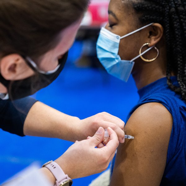 A student receives a COVID-19 vaccine.