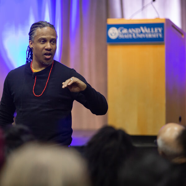man standing in front of seated audience