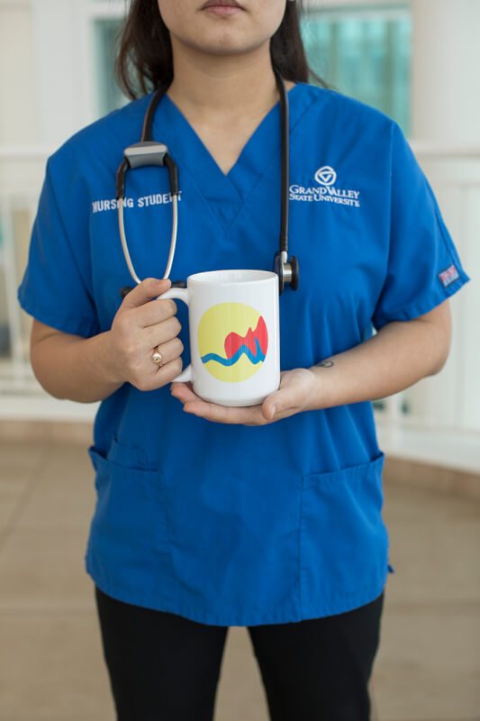 woman holding coffee cup in scrubs