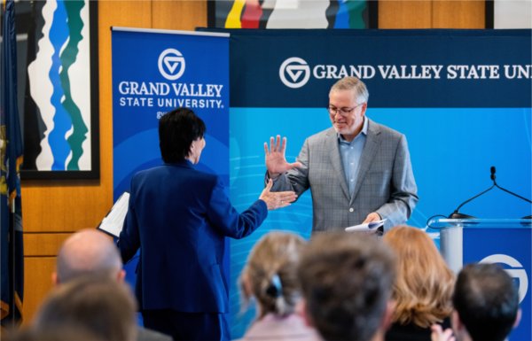 Randy Thelen, President and CEO of The Right Place, introduces President Philomena V. Mantella, left, to speak at a press conference to share GVSU&#8217;s economic impact report.