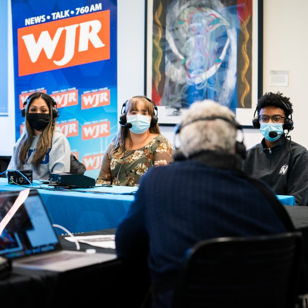 Three Grand Valley students pictured with Guy Gordon, radio host on WJR.