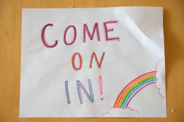 The words "come on in!" written in crayon with a drawing of a rainbow.