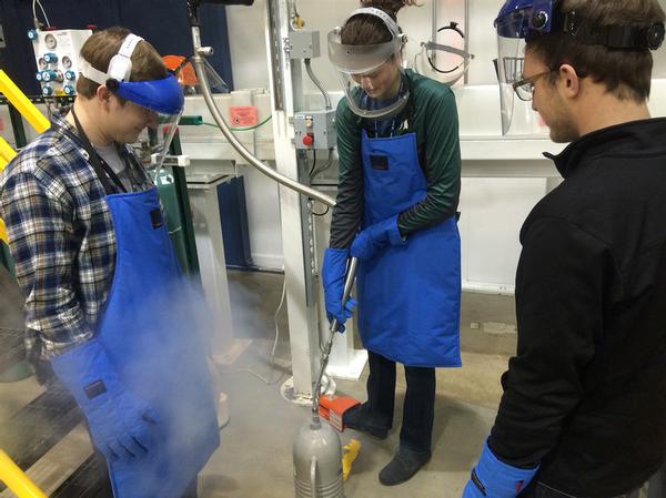 Students Joel Francis, Josie Werner and Aaron Rosenberg filling a container with liquid nitrogen at Argonne.