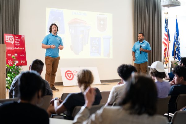Two small business owners present their idea on stage during 5 by 5 Night